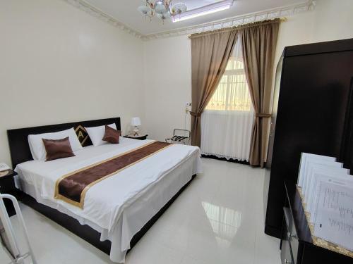 a bedroom with a large bed and a window at العييري للشقق المخدومة النعيرية 4 in Al Nairyah