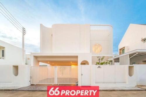 a white house with a sign in front of it at Modern 4 BR Home - Walk to Shopping and Supermarket in Chiang Mai