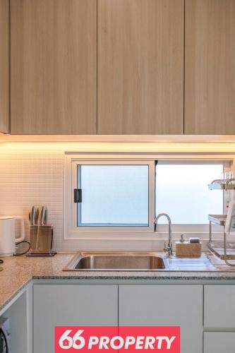 a kitchen with a sink and two windows at Modern 4 BR Home - Walk to Shopping and Supermarket in Chiang Mai