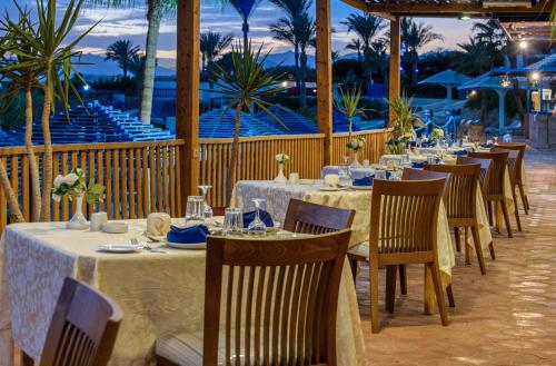 a restaurant with tables and chairs with a view of the ocean at Grand Oasis Resort in Sharm El Sheikh