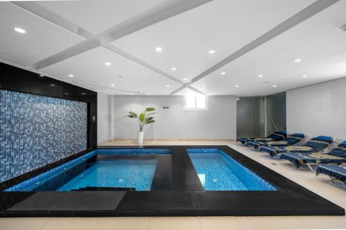 a pool in a room with chairs and a large screen at Grand Oasis Resort in Sharm El Sheikh