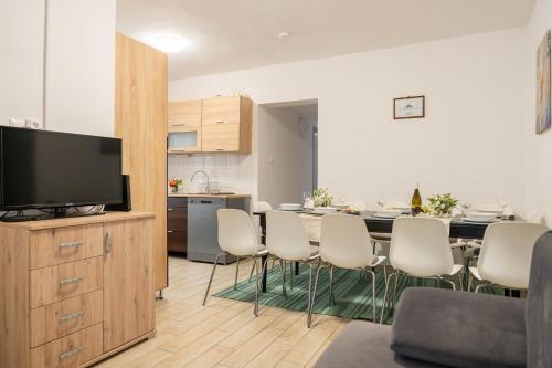 a kitchen and a dining room with a table and chairs at Esprit Apartmanház in Szajol