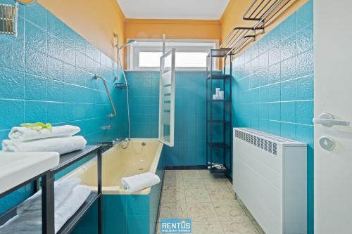 a blue bathroom with a tub and a sink at Yde et Maré - single level home with garden in Middelkerke