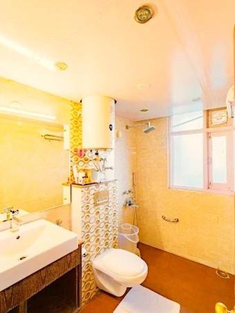 ein Badezimmer mit einer weißen Toilette und einem Waschbecken in der Unterkunft Alarks Inn in Shimla