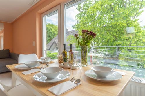a dining room table with a vase of flowers on it at Comfy Apartment Köln in Cologne