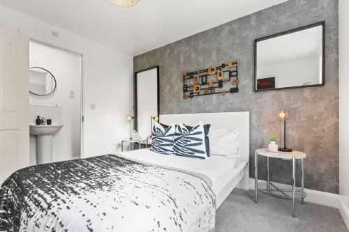 a bedroom with a large bed and a mirror at Spacious 3-Bed Home, Parking, Garden, Sleeps 7 in Brettell Lane