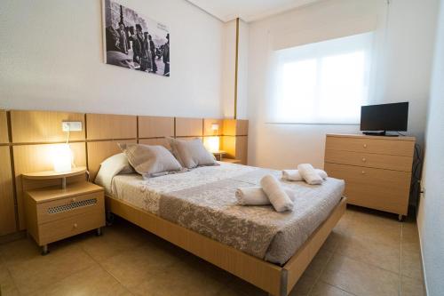 a bedroom with a bed with two towels on it at Apartamento en Magic World in Oropesa del Mar