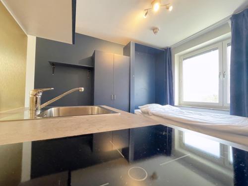 a kitchen with a sink and a counter with a window at Allihoop Ängby Aces in Stockholm