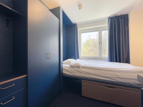 a small bedroom with a bed and a window at Allihoop Ängby Aces in Stockholm