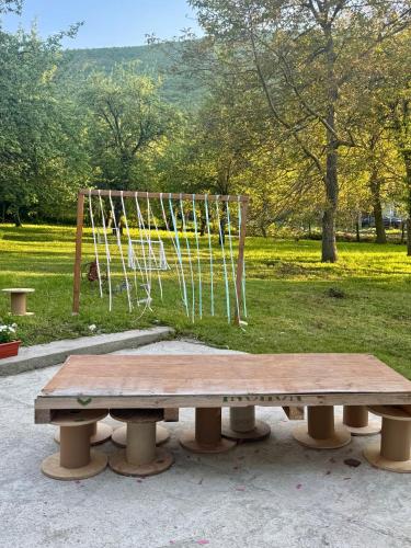 a picnic table in a park with a swing at Idila pod Rtnjem - Najam cele vikendice sa bazenom in Ilino