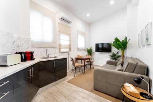 Una cocina y una sala de estar con un sofá y una mesa. en Acropolis Royal Suite, en Atenas