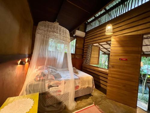 a bedroom with a bed in a wooden room at VILA AMZ, 3 minutos da Praia do Lago! in Alter do Chao