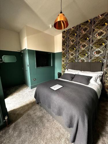 a bedroom with a large bed with a green wall at The Crown Rooms in London
