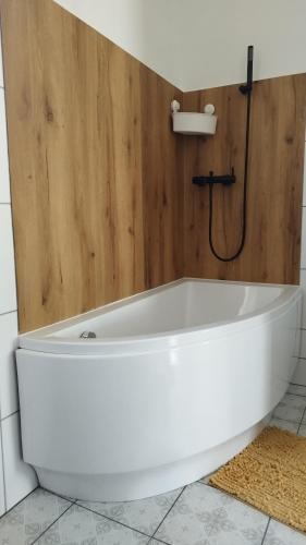 a white bath tub in a bathroom with a shower at Pannovitéz vendégház in Pannonhalma