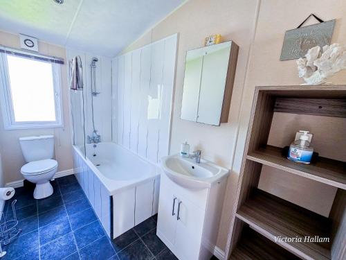 a bathroom with a sink and a toilet and a tub and a sink at Sea views at Serenity! in Truro