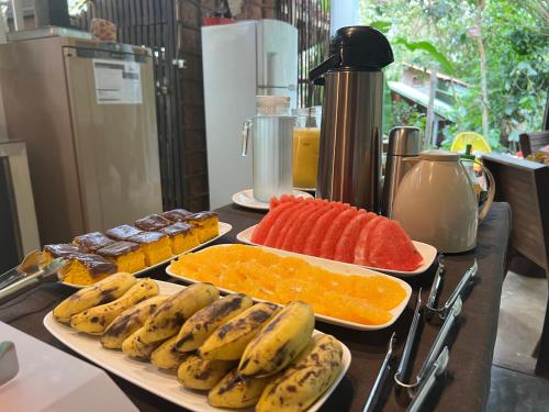 two trays of fruit on a counter with plates of food at VILA AMZ, 3 minutos da Praia do Lago! in Alter do Chao
