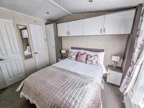 a bedroom with a large bed with pink pillows at Sea views at Serenity! in Truro