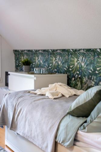 a bedroom with a bed with a floral headboard at Esprit Apartmanház in Szajol