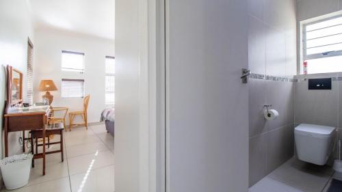 ストランドにあるGreenways Strand Golf Beach C3のバスルーム(シャワー、トイレ付)、デスクが備わります。