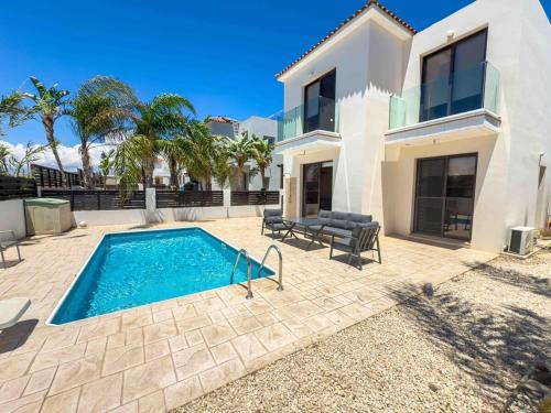 une piscine devant une maison dans l'établissement Villa Helen, à Paralímni