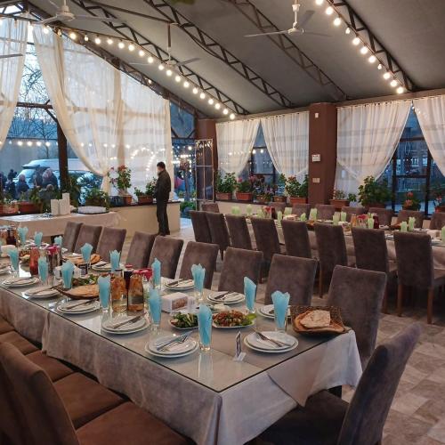 a dining room with a long table and chairs at Nohurçay Cottages & Restaurant in Gabala