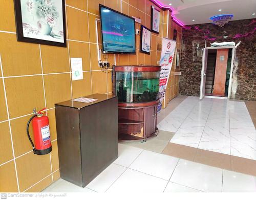 a room with a fish tank and a tv on a wall at العييري للوحدات السكنيه المفروشة الاحساء 5 in Al Hofuf