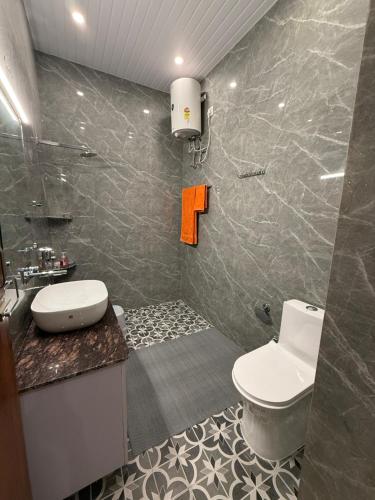 デヘラードゥーンにあるUrban Valley Casaのオレンジ色の標識が付いたトイレと洗面台のあるバスルーム