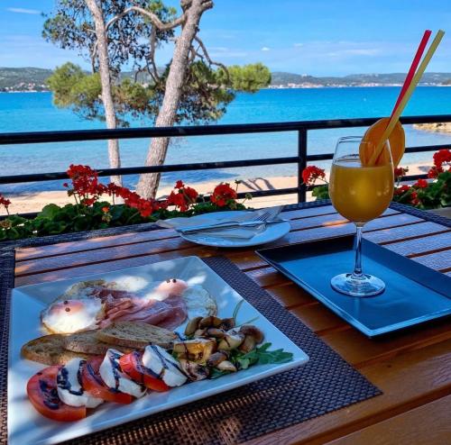 a table with a plate of sushi and a glass of orange juice at Mobile Home Ana Mia in Biograd na Moru
