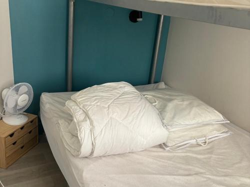 - un lit avec des draps et des oreillers blancs dans l'établissement 2 pièces RDJ climatisé avec accès piscine, tennis, golf et plus, proche Méditerranée et Massif de l'Estérel - FR-1-504-685, à Saint-Raphaël