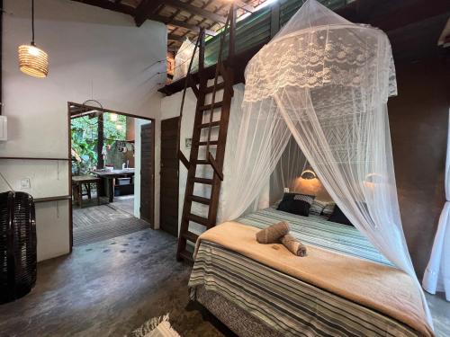 a bedroom with a bed with a canopy at VILA AMZ, 3 minutos da Praia do Lago! in Alter do Chao
