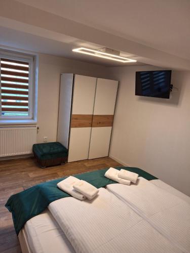 a bedroom with a large bed with two towels on it at APARTMÁNY Sninský dvor in Snina