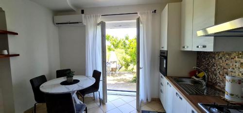 a kitchen with a small table and a door to a patio at Holiday House ARAGONA in Cupello