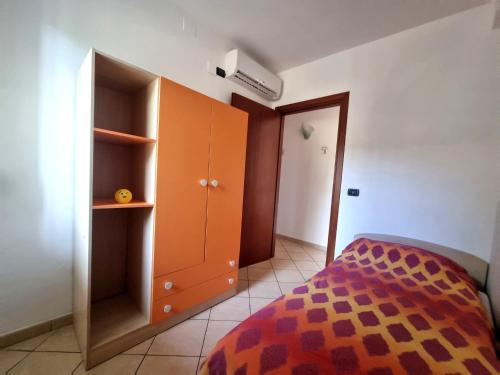 a bedroom with an orange cabinet and a bed at Holiday House ARAGONA in Cupello