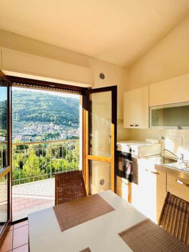 a kitchen with a table and a large window at Accogliente Appartamento con Balcone Panoramico Fino a 3 Persone, Vicino al Centro Storico in Fiuggi