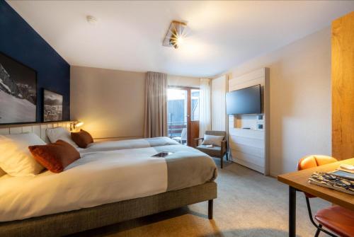 a hotel room with a bed and a desk at Belambra Clubs Les Saisies - Les Embrunes - Ski pass included in Villard-sur-Doron