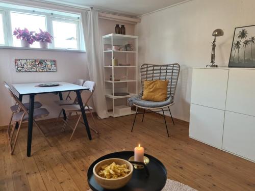 a living room with a table and a candle at Hyggelig ferielejlighed m have tæt på søerne in Silkeborg