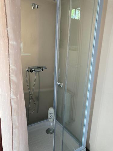 a shower with a glass door in a bathroom at Hyggelig ferielejlighed m have tæt på søerne in Silkeborg