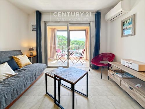 un salon avec un canapé et une table dans l'établissement La Roseraie Calvi, bord de mer, à Calvi