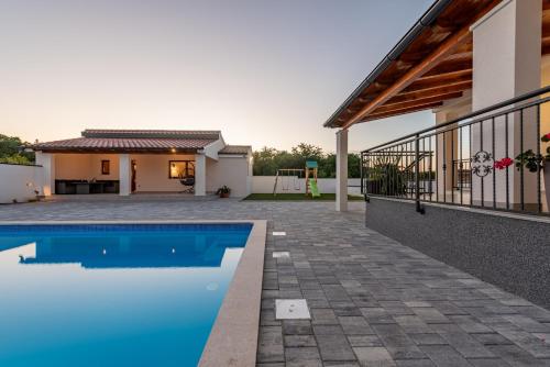 a villa with a swimming pool and a house at Villa Chivas ZadarVillas in Donje Raštane