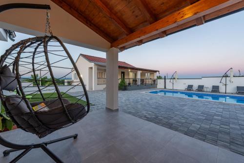a swing hanging from a porch of a house at Villa Chivas ZadarVillas in Donje Raštane