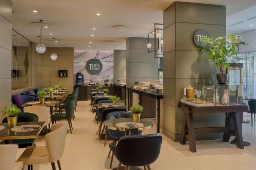 a restaurant with tables and chairs and a counter at NH Collection Porta Nuova in Milan