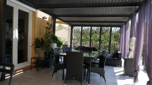 une salle à manger avec une table et des chaises sur un balcon dans l'établissement Villa calme avec piscine Luberon, à La Roque-dʼAnthéron