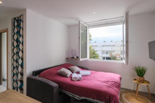 - une chambre avec un lit rose et des serviettes dans l'établissement Le Manoë- Proche GareSt Nazaire, à Saint-Nazaire