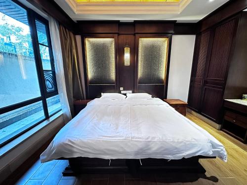 a bedroom with a large bed with white sheets at Perfume Bay Tianhai Meiya B&B in Lingshui