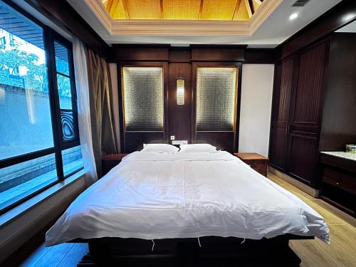 a bedroom with a large bed and a large window at Perfume Bay Tianhai Meiya B&B in Lingshui