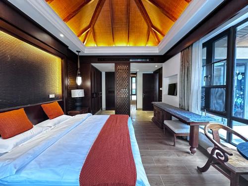 a bedroom with a large bed and a desk and window at Perfume Bay Tianhai Meiya B&B in Lingshui