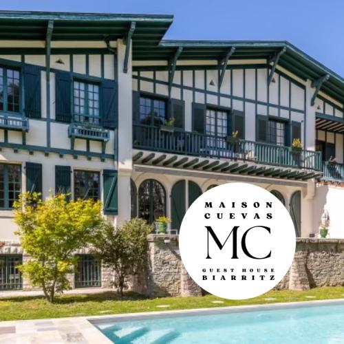 une villa avec un panneau en face d'un bâtiment dans l'établissement Maison Cuevas, à Biarritz