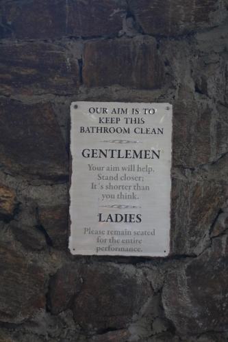 a sign on the side of a stone wall at Passion Hills in Udawalawe