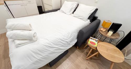 Elle comprend un grand lit avec des draps et des oreillers blancs. dans l'établissement Hypercenter - Close to Place des Corps Saints, à Avignon