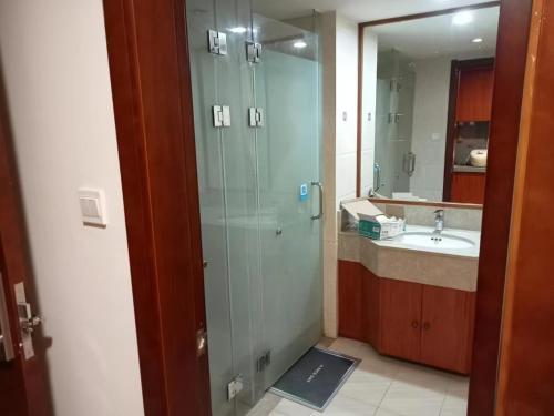 a bathroom with a glass shower and a sink at Perfume Bay Tianhai Meiya B&B in Lingshui